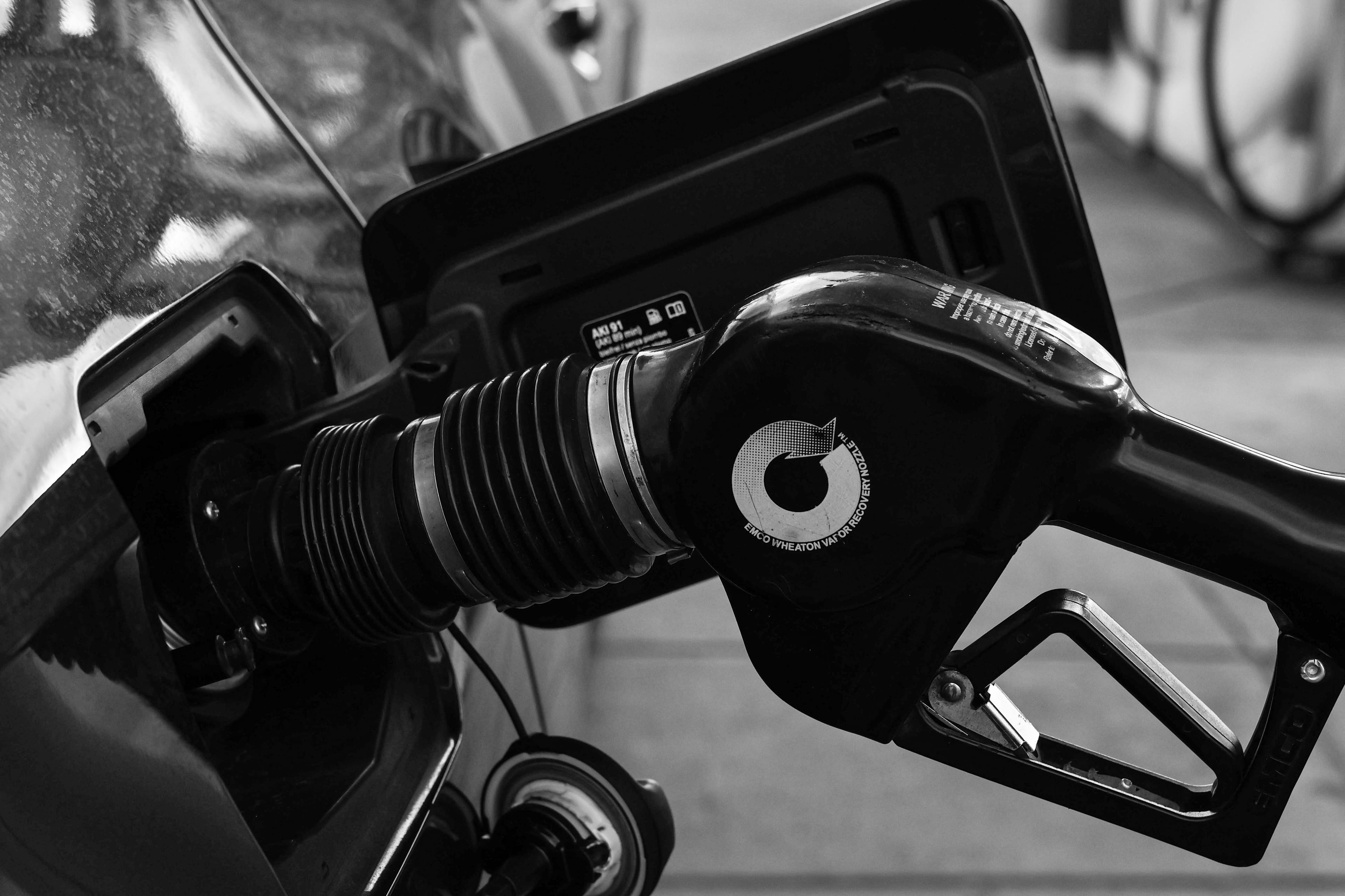 A close-up of a fuel pump nozzle inserted into a car's gas tank.